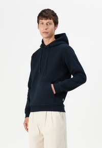 Navy blue hoodie made of soft fabric with a front pocket, adjustable drawstring hood, and ribbed cuffs for a snug fit.