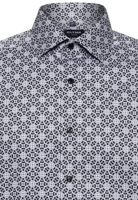 Zwart-witte gestreepte shirt met een puntkraag, knoopsluiting aan de voorkant en complexe geometrische ontwerpen op een gladde stof.