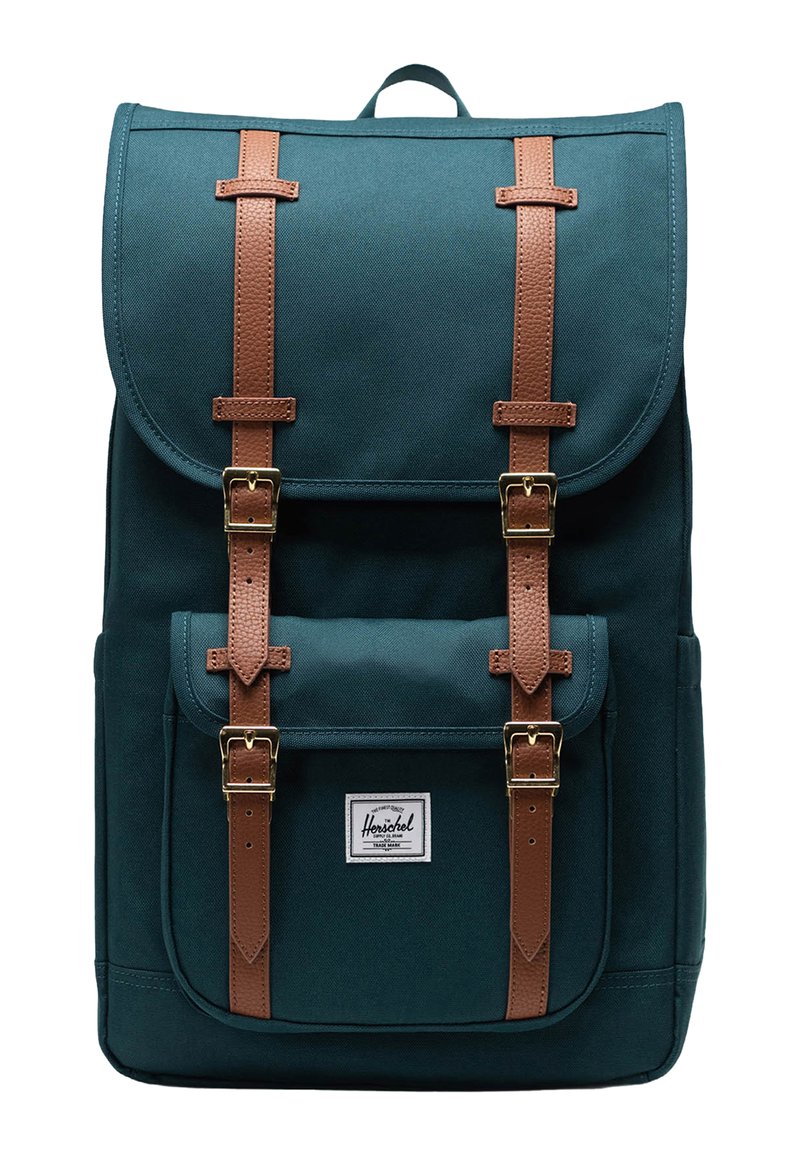 Tealfärgad kanvasryggsäck med bruna läderremmar och gyllene spännen. Har en framficka och en märkestikett på botten.