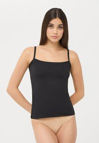 Camisola nera con sottili spalline regolabili e scollatura quadrata, realizzata in tessuto liscio, abbinata a slip bikini color nudo.