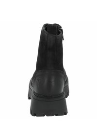 Botín de cuero negro hasta el tobillo con una parte superior texturizada, tacón reforzado y suela de goma resistente. Presenta un lazo para facilitar el calzado.