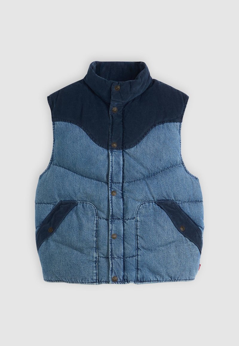 Blå denimvest med høj krave, polstret tekstur og marineblå kordfløjl-accenter. Har to forlommer og knaplukninger.