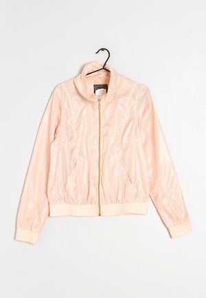 Světlé růžové lesklé bomber bunda s vysokým límcem, zipem vpředu a elastickými manžetami a lemem. Obsahuje dvě boční kapsy.