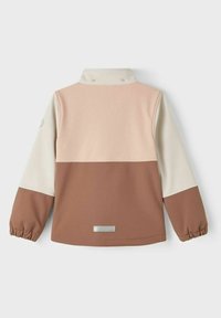 Leichte, farblich abgestimmte Jacke mit braunem unteren Abschnitt, hellem Pfirsich-Oberpanel und cremfarbigen Ärmeln. Elastische Bündchen und Logodetail.