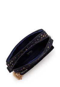 Cartera navy con cremallera con patrón de estrellas doradas, múltiples compartimentos, interior forrado y un pequeño charm de mono adjunto. Material de tela duradera.
