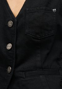 Μαύρο denim μπουφάν με μεταλλικά κουμπιά χαραγμένα "PINKO", τσέπη στο στήθος με μικρή μεταλλική λεπτομέρεια λογότυπου και κάτω τσέπη με σχίσιμο.