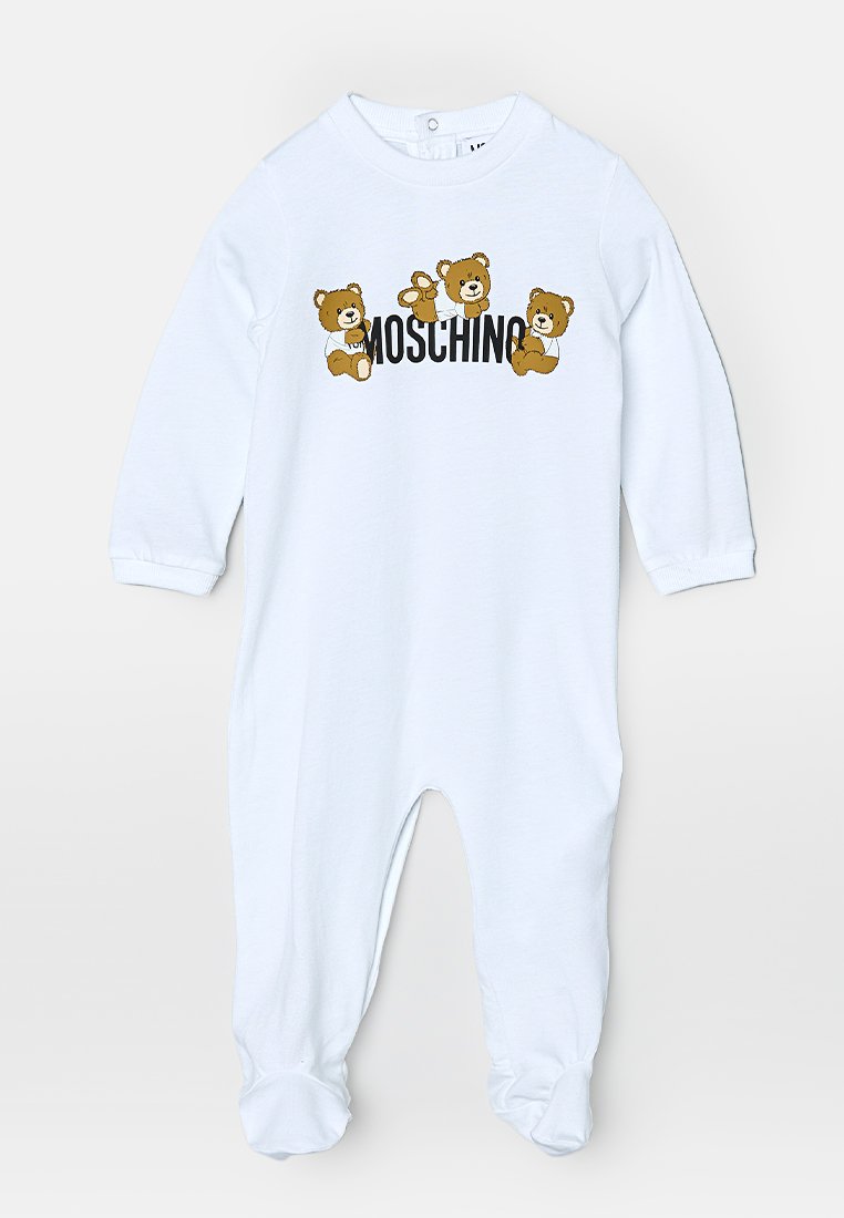 Combinaison en coton blanc ornée de graphiques de petits ours avec le texte "Moschino". Manches longues et design pieds complets avec une fermeture à pression au niveau du cou.