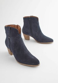 Bocanci de gleznă din suede bleu marin, cu vârf ascuțit, toc din lemn stratificat și fermoar lateral, având detalii decorative de cusătură.