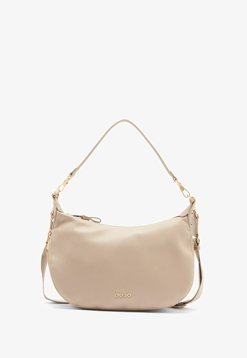 Sac à main en cuir beige avec une bandoulière et du matériel doré, présentant un logo de marque subtil à l'avant.