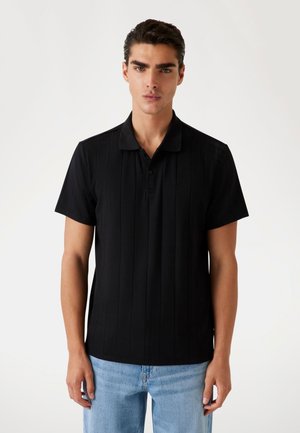 Black polo shirt featuring vertical stripes, short sleeves, a collared neckline, and button closure. Made of soft, textured fabric.