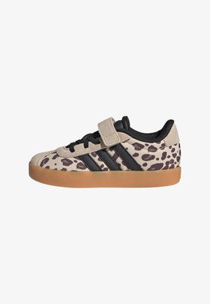 Zapatilla baja con estampado de leopardo en beige y negro, rayas negras, tira de ante beige, cordones negros y suela de goma.
