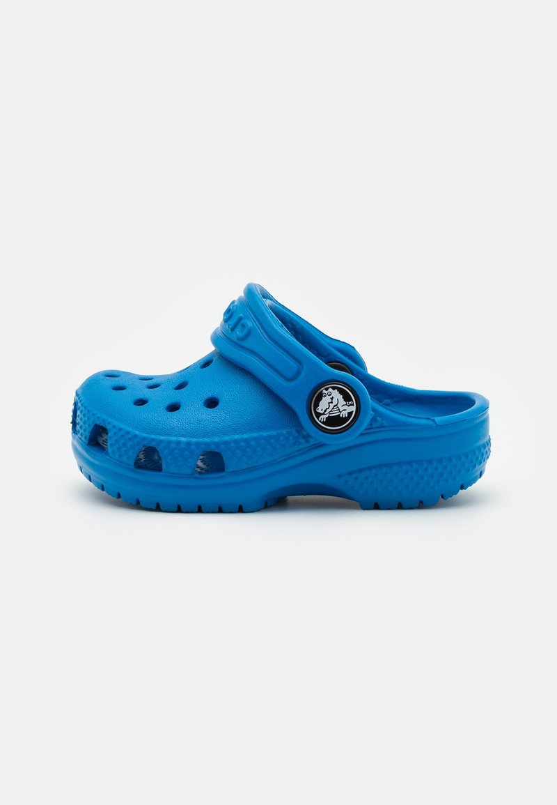 Sabot bleu à dos fermé en mousse légère, doté de trous de ventilation, d'une semelle texturée et d'une sangle de talon amovible avec détail de logo.