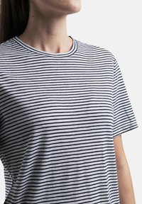 Camiseta de manga corta a rayas en blanco y navy, con un cuello redondo y una textura suave de algodón; rayas horizontales espaciadas uniformemente.