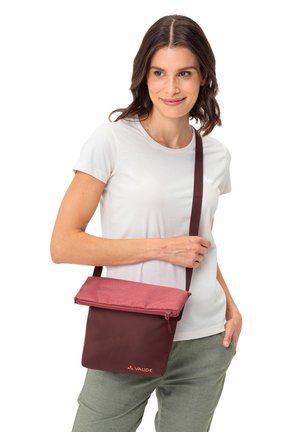 Bolso bandolera color granate con solapa superior rosa, cierre de cremallera y correa ajustable. Textura suave con un logo en el panel frontal.