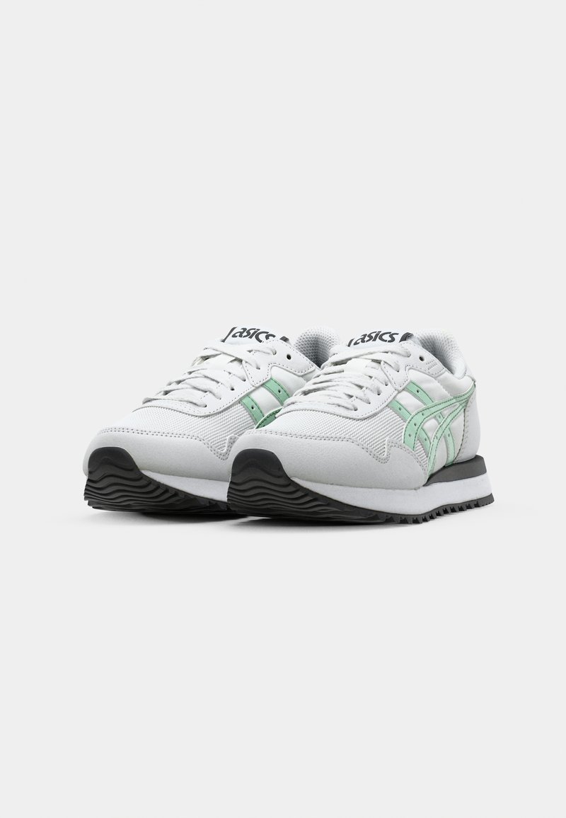 Scarpe da ginnastica bianche con accenti verde menta, superiore in rete e sintetico, suola in gomma testurizzata e outsole nera a contrasto.