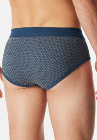 Blauwe gestreepte slip met een geometrisch patroon, een textuur oppervlak en een stevige tailleband. Blootgesteld stof met een soepel pasvorm.
