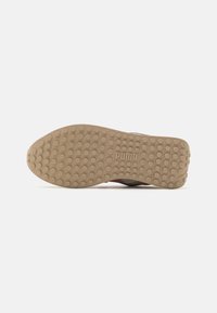 Sola in gomma per sneakers con modelli di presa arrotondati, di colore beige. Presenta un battistrada testurizzato per migliorare la trazione e un logo del marchio impresso sul tallone.