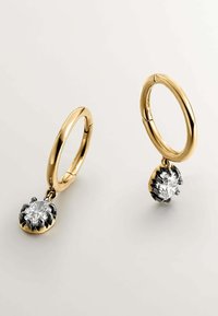 Pendientes de aro de oro que presentan una piedra preciosa clara colgante, montada en una base de metal oscuro, con un acabado pulido y un detallado intrincado.