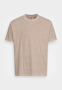 Beige puuvillane T-särk ümmarguse kaelusega, lühikeste varrukatega ja kerge tekstuuriga. Esiküljel on väike tikand logoga.