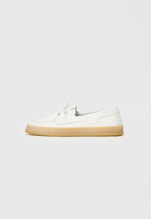 Weiße Freizeit-Schuhe mit einer strukturierten Oberseite, Schnürverschluss und einer hellbraunen Gummisohle. Mit gestickten Details und dezenten Logoakzenten.