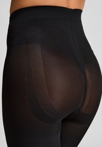Schwarze, durchsichtige Leggings mit einem hohen Taillenbund, die eine glatte Textur und ein dezentes, mattes Finish aufweisen und die Beinform betonen.