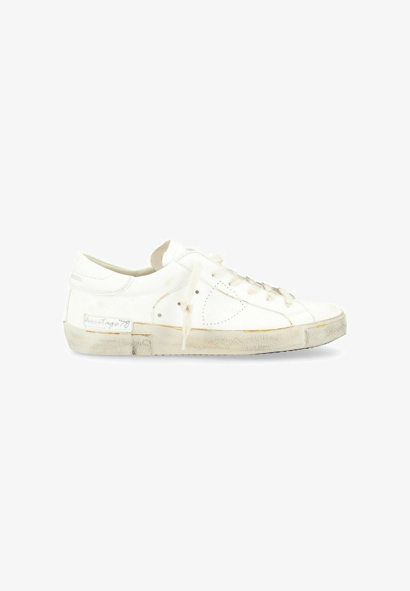 Sneaker bassa bianca con tomaia in pelle liscia, punta rotonda, chiusura con lacci e suola in gomma leggermente consumata, con branding discreto.