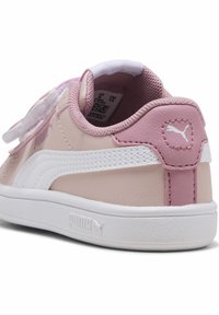 Sneakers rose et crème avec une tige en cuir lisse, un col rembourré et des accents blancs. Comprend une semelle texturée avec un logo.