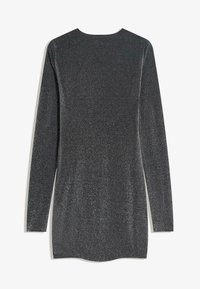 Fekete, csillogó anyagból készült, hosszú ujjú tunika; kerek nyakkivágással és enyhén ívelt aljjal rendelkezik.