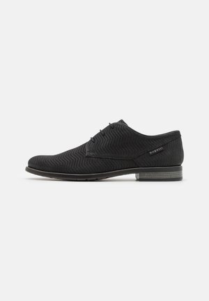 Chaussure formelle noire avec un motif en chevrons texturé. Présente un bout rond, un design à lacets, et un talon empilé gris.