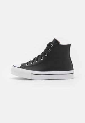 Schwarzer High-Top-Sneaker mit weißer Gummisohle und Zehenkappe, schwarzen Schnürsenkeln und Metallösen, seitlich auf weißem Hintergrund abgebildet.