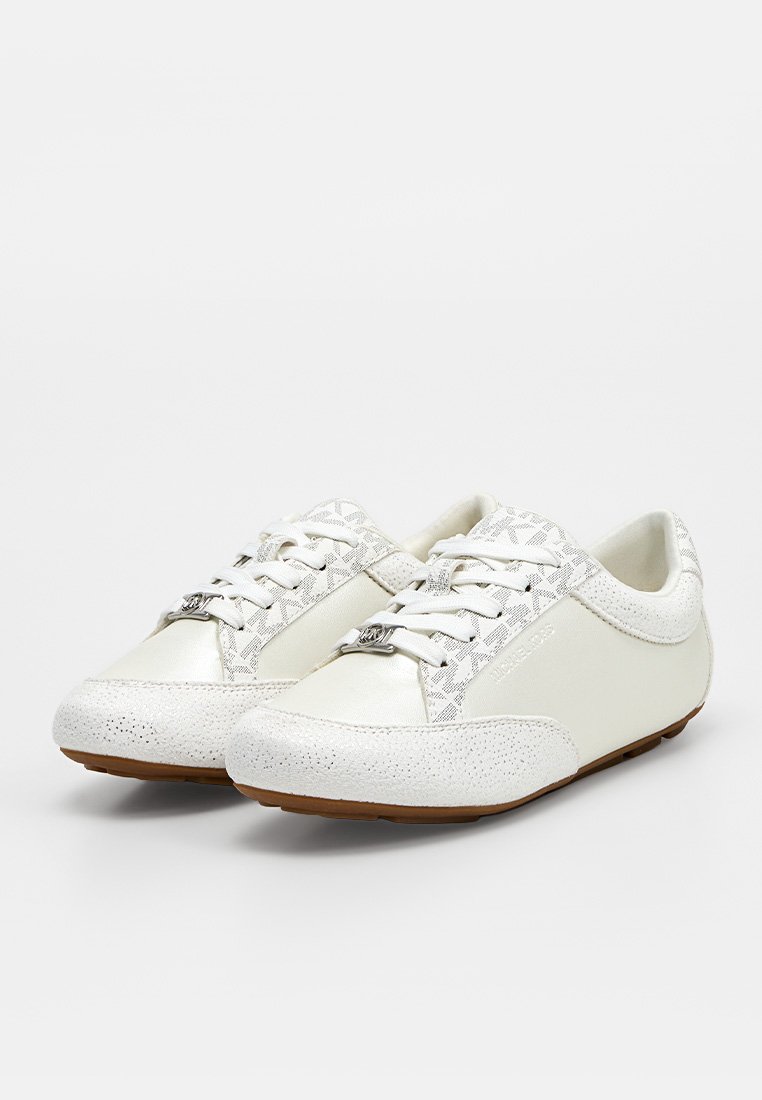Par de zapatillas bajas blancas con punteras texturizadas, laterales con patrones, cordones blancos y suelas marrones sobre un fondo liso.