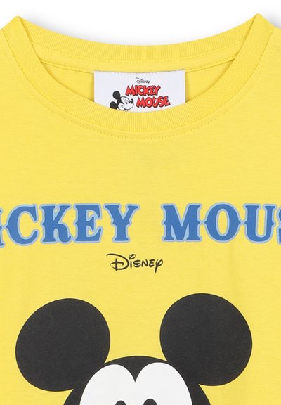 Żółta bawełniana koszulka z niebieskim napisem "MICKEY MOUSE" nad czarno-białym grafiką Micky'ego Mouse'a. Widoczne metki przy dekolcie.