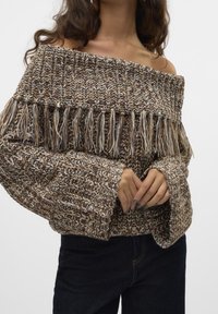 Sweter na drutach z odkrytymi ramionami w kolorach brązu, beżu i kremu z frędzlami. Luźny krój i szerokie rękawy, teksturowany wzór z przędzy.