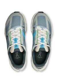 Baskets de course gris clair avec tige en mesh, accents bleus, lacets verts et semelle rembourrée. Comprend le logo sur la languette et la semelle intérieure.