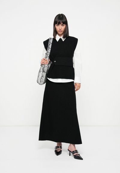 Black wool blend vest with structured shoulders, layered over a white shirt; paired with a black skirt and pointed toe mules. Accessorized with a snake print bag.