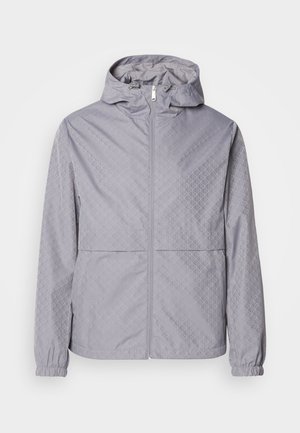 Casaco com capuz cinza claro, com um padrão geométrico, fecho de correr, punhos elásticos e dois bolsos frontais; feito de um material liso e resistente à água.