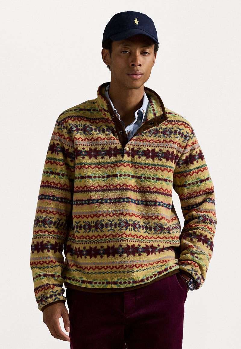 Fleece pullover in multicolored patterned knit with yellow, red, and green stripes. Features a brown collar and buttoned neckline.