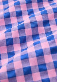 Baumwollstoff mit einem karierten Muster in Pink und Blau. Glatte Textur mit klaren Quadraten, die abwechselnd in den Farben angeordnet sind.