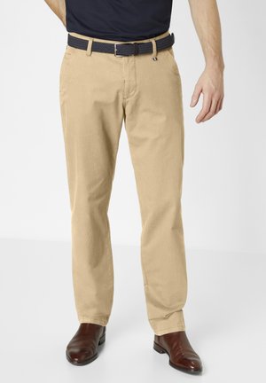 Beige cotton chinos with a straight cut, featuring side pockets and a braided navy belt with a silver buckle. Brown leather shoes.