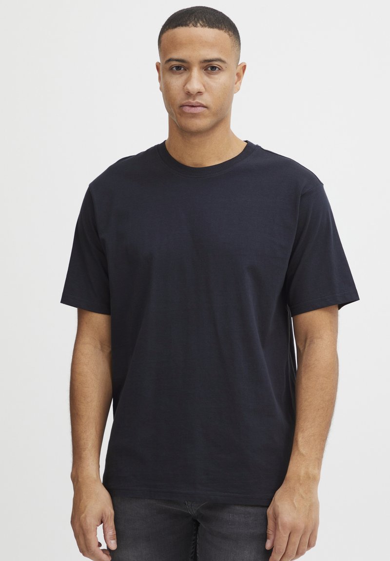 Tricou negru cu mânecă scurtă și guler rotund, realizat din bumbac moale. Croială lejeră cu un design simplu, având un decolteu curat și fără modele vizibile.