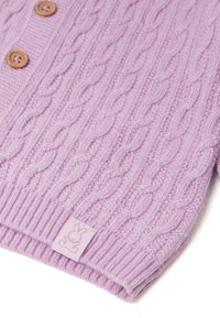 Svetr s kabelovým pletením v světle fialové barvě, s dřevěnými knoflíky a vroubkovaným lemem. Obsahuje malou, texturovanou štítek s logem králíka.