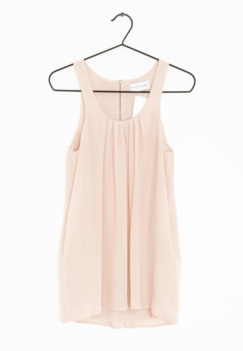 Jasnoróżowa bezrękawnik wykonana z lekkiego materiału, z plisowanym przodem i zamkiem błyskawicznym z tyłu, wisząca na czarnym wieszaku.