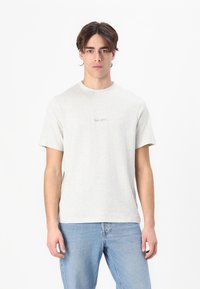 T-shirt grigio chiaro a girocollo realizzato in tessuto morbido, con il logo minimalista "LES DEUX" cucito al centro. Vestibilità casual, maniche corte.