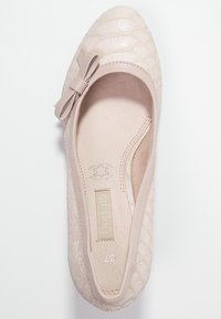 Ballerine en cuir rose clair avec un motif texturé et embossé, ornée d'un petit noeud sur le bout. Intérieur avec une doublure douce. Taille 37.