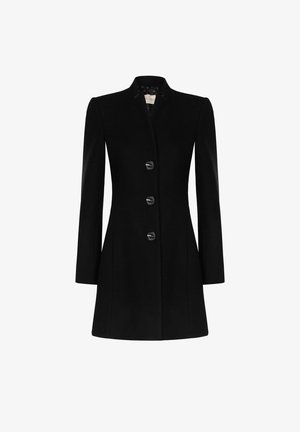Manteau noir pour femme sur mesure avec manches longues, trois boutons devant et un ourlet légèrement évasé sur fond blanc.