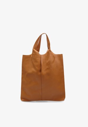 Tan leather tote bag with a textured surface, two long handles, and a minimalist design. Features a central seam for structure.