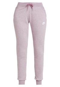 Ljusrosa Nike-joggers med dragsko i midjan, elastiska muddar och en liten vit logotyp på vänster lår. Tillverkade av mjukt, texturerat material.