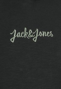 T-shirt in tessuto nero con logo ricamato verde chiaro che recita "Jack & Jones", con una texture morbida e collo a costine.