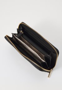 Zwarte leren portemonnee met een gouden rits, meerdere kaartsleuven, een ritsvak voor munten en een interieur met een licht patroon.