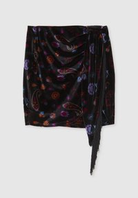 Gonna mini in velluto nero con motivi floreali e paisley in colori vivaci. Presenta drappeggi e un dettaglio frangiato su un lato.